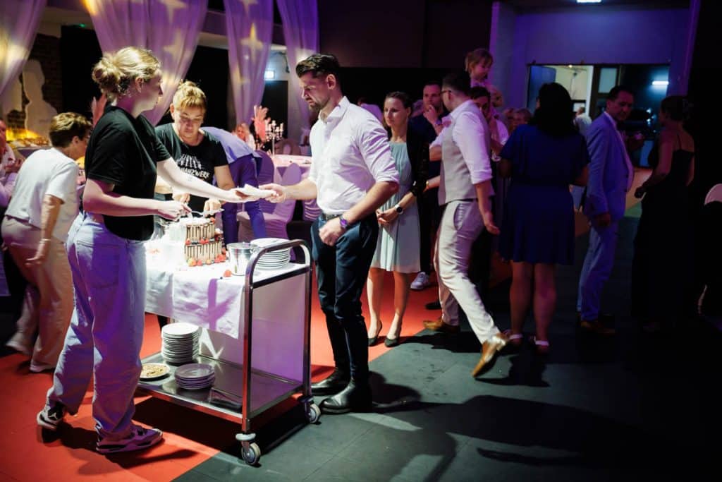 Ausgelassene Hochzeitsfeier im Resonanzwerk Oberhausen: Das Brautpaar eröffnet den Tanz, Gäste feiern ausgelassen auf der Tanzfläche und genießen das festliche Ambiente. Lebendige Reportagebilder voller Emotionen, aufgenommen vom Hochzeitsfotograf Duisburg.