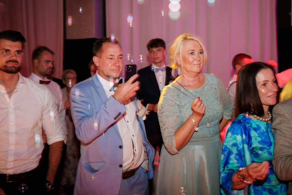 Ausgelassene Hochzeitsfeier im Resonanzwerk Oberhausen: Das Brautpaar eröffnet den Tanz, Gäste feiern ausgelassen auf der Tanzfläche und genießen das festliche Ambiente. Lebendige Reportagebilder voller Emotionen, aufgenommen vom Hochzeitsfotograf Duisburg.