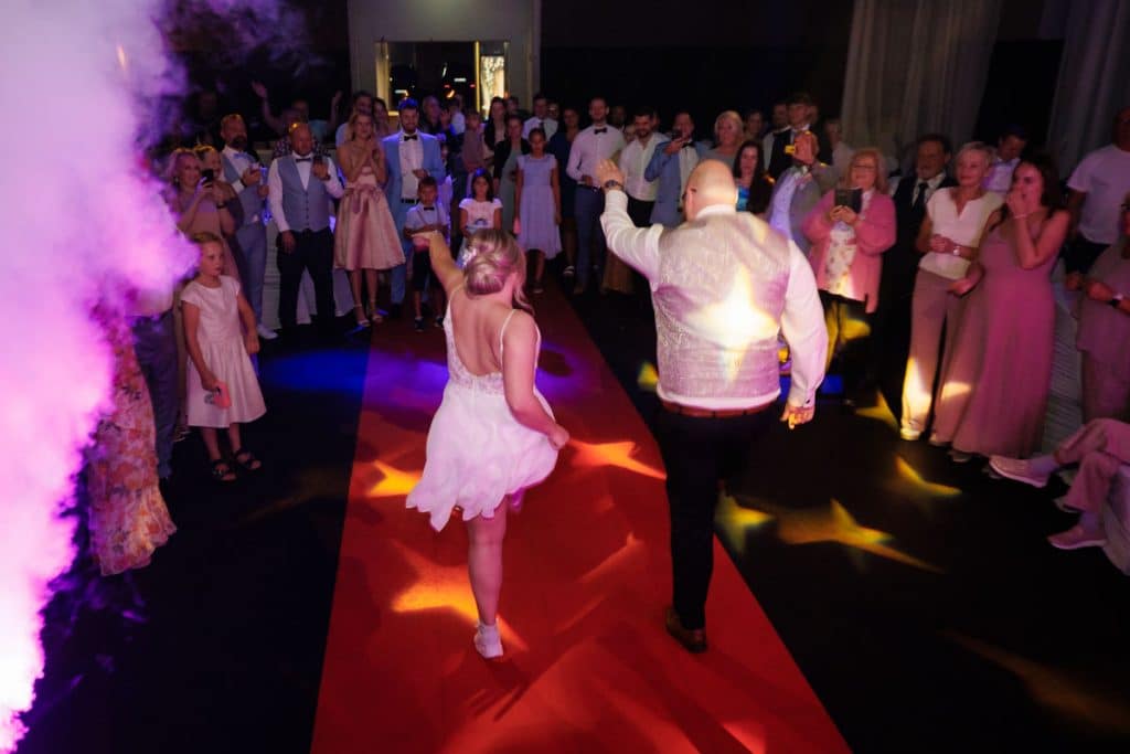 Ausgelassene Hochzeitsfeier im Resonanzwerk Oberhausen: Das Brautpaar eröffnet den Tanz, Gäste feiern ausgelassen auf der Tanzfläche und genießen das festliche Ambiente. Lebendige Reportagebilder voller Emotionen, aufgenommen vom Hochzeitsfotograf Duisburg.