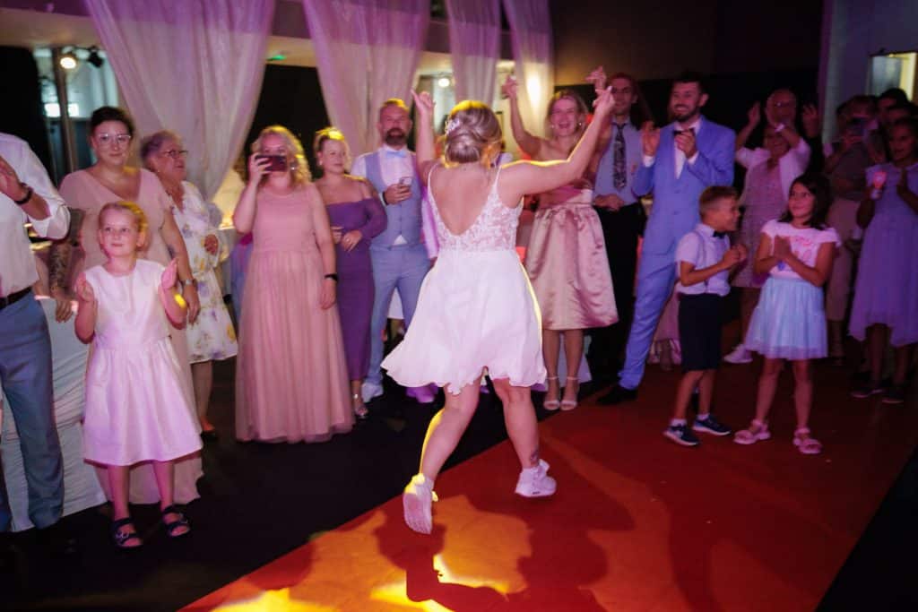 Ausgelassene Hochzeitsfeier im Resonanzwerk Oberhausen: Das Brautpaar eröffnet den Tanz, Gäste feiern ausgelassen auf der Tanzfläche und genießen das festliche Ambiente. Lebendige Reportagebilder voller Emotionen, aufgenommen vom Hochzeitsfotograf Duisburg.