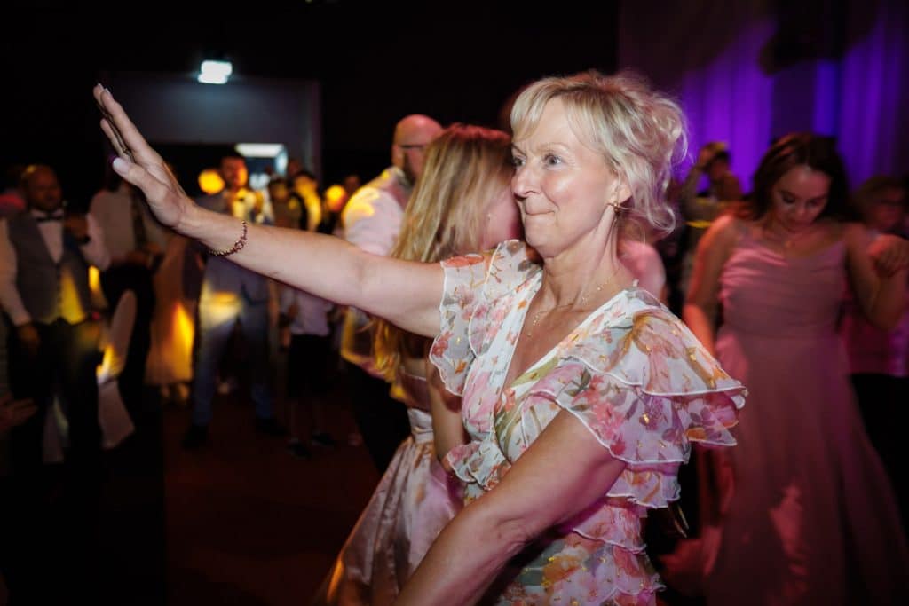 Ausgelassene Hochzeitsfeier im Resonanzwerk Oberhausen: Das Brautpaar eröffnet den Tanz, Gäste feiern ausgelassen auf der Tanzfläche und genießen das festliche Ambiente. Lebendige Reportagebilder voller Emotionen, aufgenommen vom Hochzeitsfotograf Duisburg.