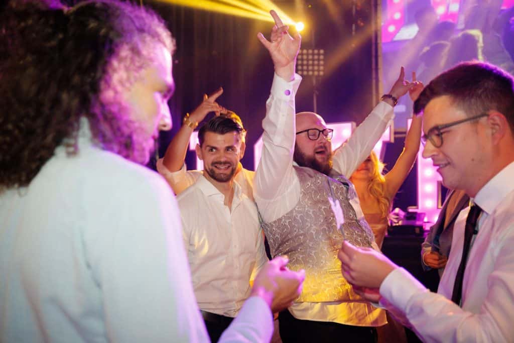 Ausgelassene Hochzeitsfeier im Resonanzwerk Oberhausen: Das Brautpaar eröffnet den Tanz, Gäste feiern ausgelassen auf der Tanzfläche und genießen das festliche Ambiente. Lebendige Reportagebilder voller Emotionen, aufgenommen vom Hochzeitsfotograf Duisburg.