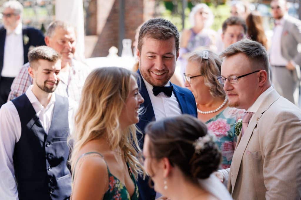 Feierliche Momente nach der Trauung im Schloss Diersfordt in Wesel: Gäste gratulieren dem Brautpaar herzlich, es entstehen weitere Gruppenfotos und beim Sektempfang wird mit Sekt angestoßen. Der Anschnitt der Hochzeitstorte sorgte für zusätzliche emotionale Bilder. Authentisch festgehalten vom Hochzeitsfotograf Wesel.