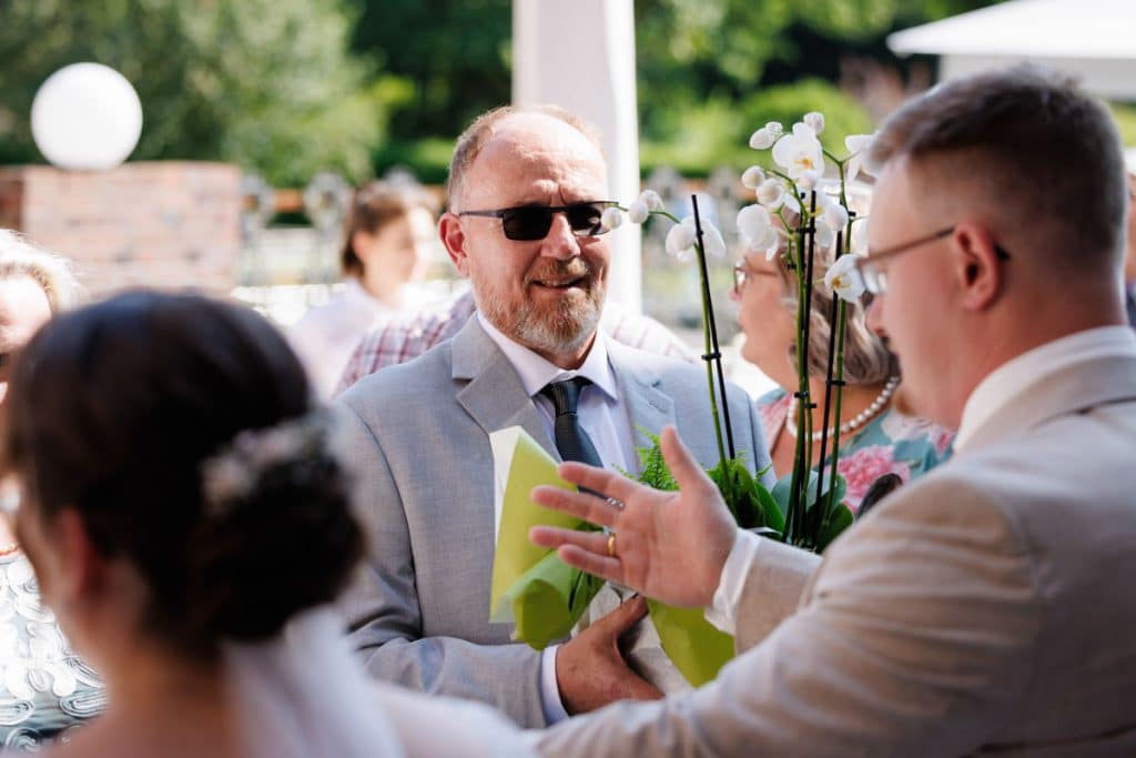 Feierliche Momente nach der Trauung im Schloss Diersfordt in Wesel: Gäste gratulieren dem Brautpaar herzlich, es entstehen weitere Gruppenfotos und beim Sektempfang wird mit Sekt angestoßen. Der Anschnitt der Hochzeitstorte sorgte für zusätzliche emotionale Bilder. Authentisch festgehalten vom Hochzeitsfotograf Wesel.