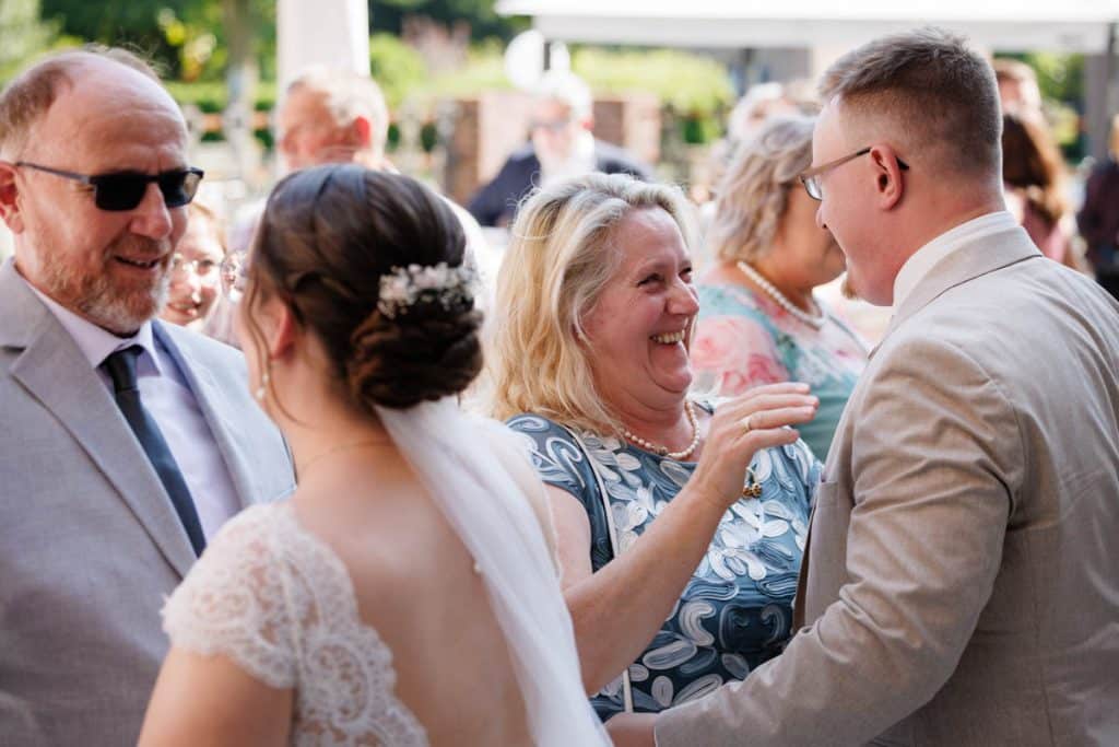 Feierliche Momente nach der Trauung im Schloss Diersfordt in Wesel: Gäste gratulieren dem Brautpaar herzlich, es entstehen weitere Gruppenfotos und beim Sektempfang wird mit Sekt angestoßen. Der Anschnitt der Hochzeitstorte sorgte für zusätzliche emotionale Bilder. Authentisch festgehalten vom Hochzeitsfotograf Wesel.