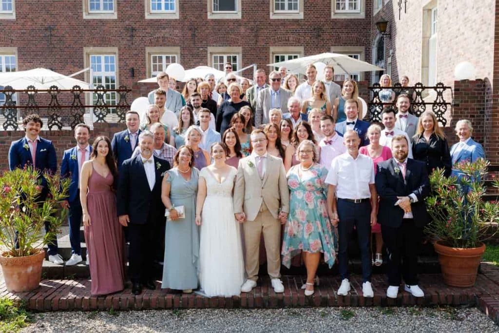 Feierliche Momente nach der Trauung im Schloss Diersfordt in Wesel: Gäste gratulieren dem Brautpaar herzlich, es entstehen weitere Gruppenfotos und beim Sektempfang wird mit Sekt angestoßen. Der Anschnitt der Hochzeitstorte sorgte für zusätzliche emotionale Bilder. Authentisch festgehalten vom Hochzeitsfotograf Wesel.