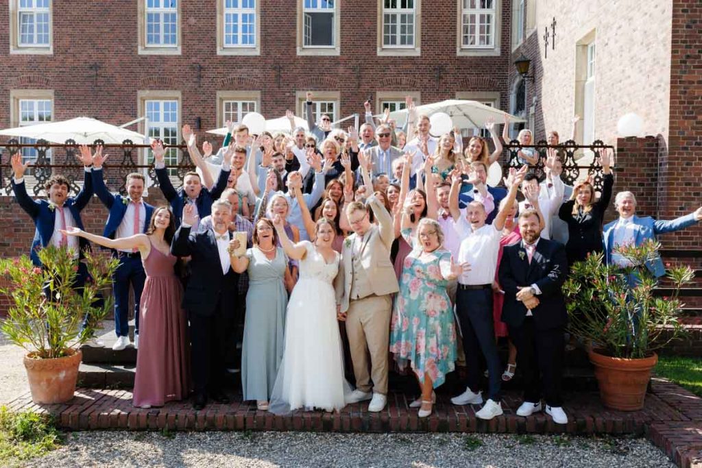 Feierliche Momente nach der Trauung im Schloss Diersfordt in Wesel: Gäste gratulieren dem Brautpaar herzlich, es entstehen weitere Gruppenfotos und beim Sektempfang wird mit Sekt angestoßen. Der Anschnitt der Hochzeitstorte sorgte für zusätzliche emotionale Bilder. Authentisch festgehalten vom Hochzeitsfotograf Wesel.
