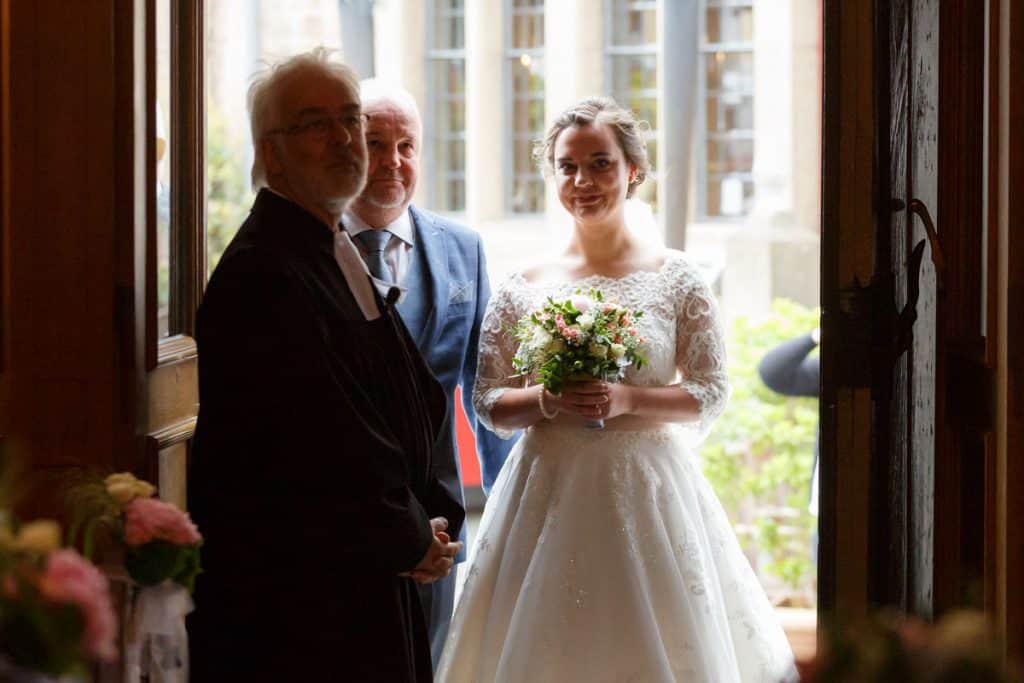 Emotionaler Moment bei der kirchlichen Trauung in der Evangelischen Kirche am Markt in Xanten: Das Brautpaar steht gemeinsam am Altar, die Braut im weißen Spitzenkleid mit Schleier, der Bräutigam im eleganten Anzug. Gäste verfolgen die Zeremonie aufmerksam in der festlich geschmückten Kirche. Dieses Foto zeigt die authentische Hochzeitsreportage vom Hochzeitsfotograf Xanten.