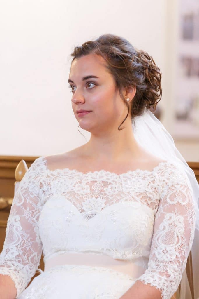 Emotionaler Moment bei der kirchlichen Trauung in der Evangelischen Kirche am Markt in Xanten: Das Brautpaar steht gemeinsam am Altar, die Braut im weißen Spitzenkleid mit Schleier, der Bräutigam im eleganten Anzug. Gäste verfolgen die Zeremonie aufmerksam in der festlich geschmückten Kirche. Dieses Foto zeigt die authentische Hochzeitsreportage vom Hochzeitsfotograf Xanten.