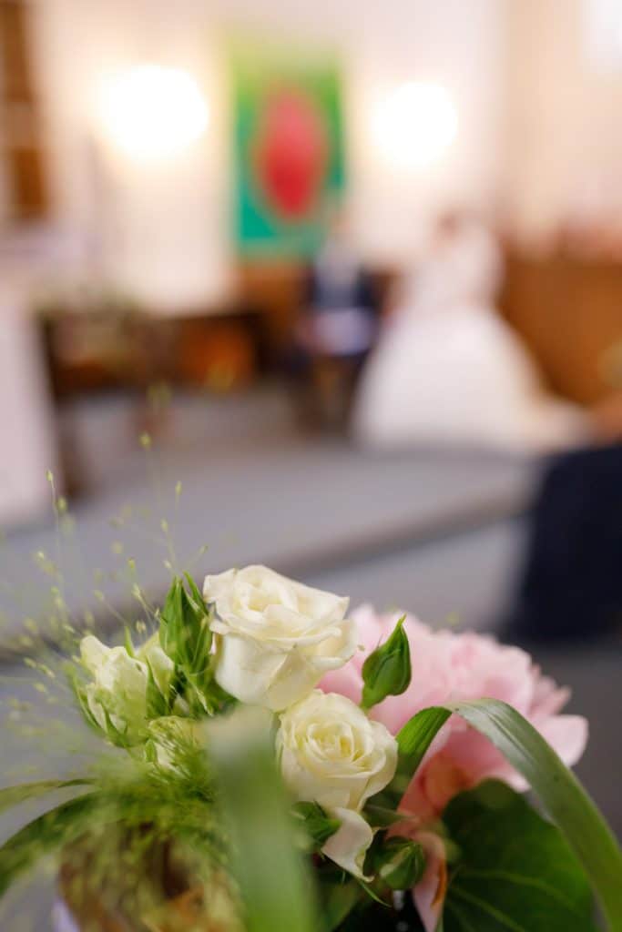 Emotionaler Moment bei der kirchlichen Trauung in der Evangelischen Kirche am Markt in Xanten: Das Brautpaar steht gemeinsam am Altar, die Braut im weißen Spitzenkleid mit Schleier, der Bräutigam im eleganten Anzug. Gäste verfolgen die Zeremonie aufmerksam in der festlich geschmückten Kirche. Dieses Foto zeigt die authentische Hochzeitsreportage vom Hochzeitsfotograf Xanten.