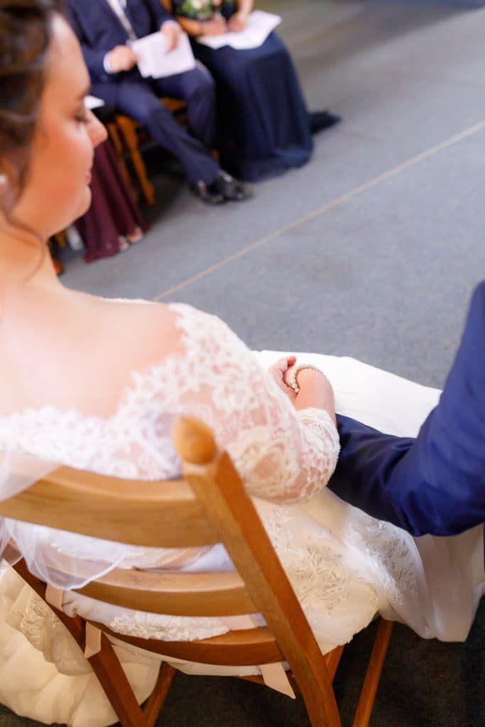 Emotionaler Moment bei der kirchlichen Trauung in der Evangelischen Kirche am Markt in Xanten: Das Brautpaar steht gemeinsam am Altar, die Braut im weißen Spitzenkleid mit Schleier, der Bräutigam im eleganten Anzug. Gäste verfolgen die Zeremonie aufmerksam in der festlich geschmückten Kirche. Dieses Foto zeigt die authentische Hochzeitsreportage vom Hochzeitsfotograf Xanten.