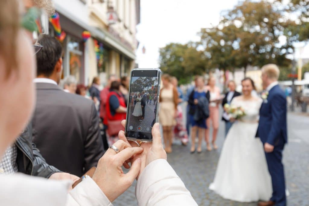Emotionaler Moment bei der kirchlichen Trauung in der Evangelischen Kirche am Markt in Xanten: Das Brautpaar steht gemeinsam am Altar, die Braut im weißen Spitzenkleid mit Schleier, der Bräutigam im eleganten Anzug. Gäste verfolgen die Zeremonie aufmerksam in der festlich geschmückten Kirche. Dieses Foto zeigt die authentische Hochzeitsreportage vom Hochzeitsfotograf Xanten.