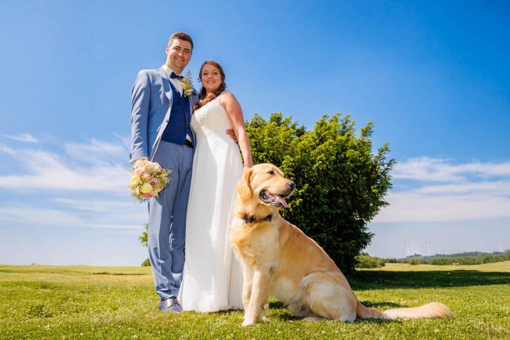Romantisches Portraitshooting mit Hund und Diana und Hendrik im Grünen des Sauerlands. Die hügelige Landschaft, Wiesen und Felder boten eine malerische Kulisse für natürliche, emotionale Hochzeitsfotos. Authentische Aufnahmen voller Liebe und Glück, fotografiert vom Hochzeitsfotograf Sauerland.